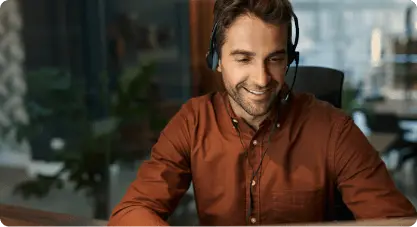 Representante de servicio al cliente sonriente con auriculares, representando el soporte 24/7 de Cars Iceland brindado por expertos locales en alquiler.