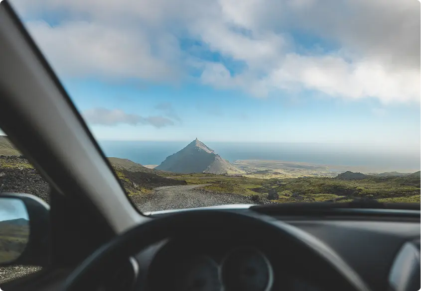 Vista aérea de la impresionante costa de Islandia y sus sinuosas carreteras, destacando los vastos paisajes accesibles con un coche de alquiler a lo largo de la Ruta Circular (Ring Road).