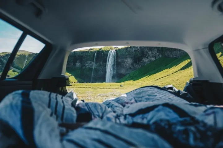 PArte trasera de una camper con vistas a una cascada