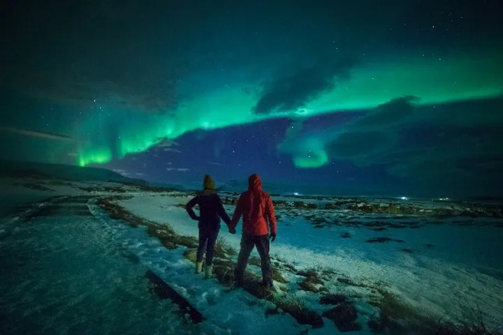 Pareja disfrutando de las auroras boreales