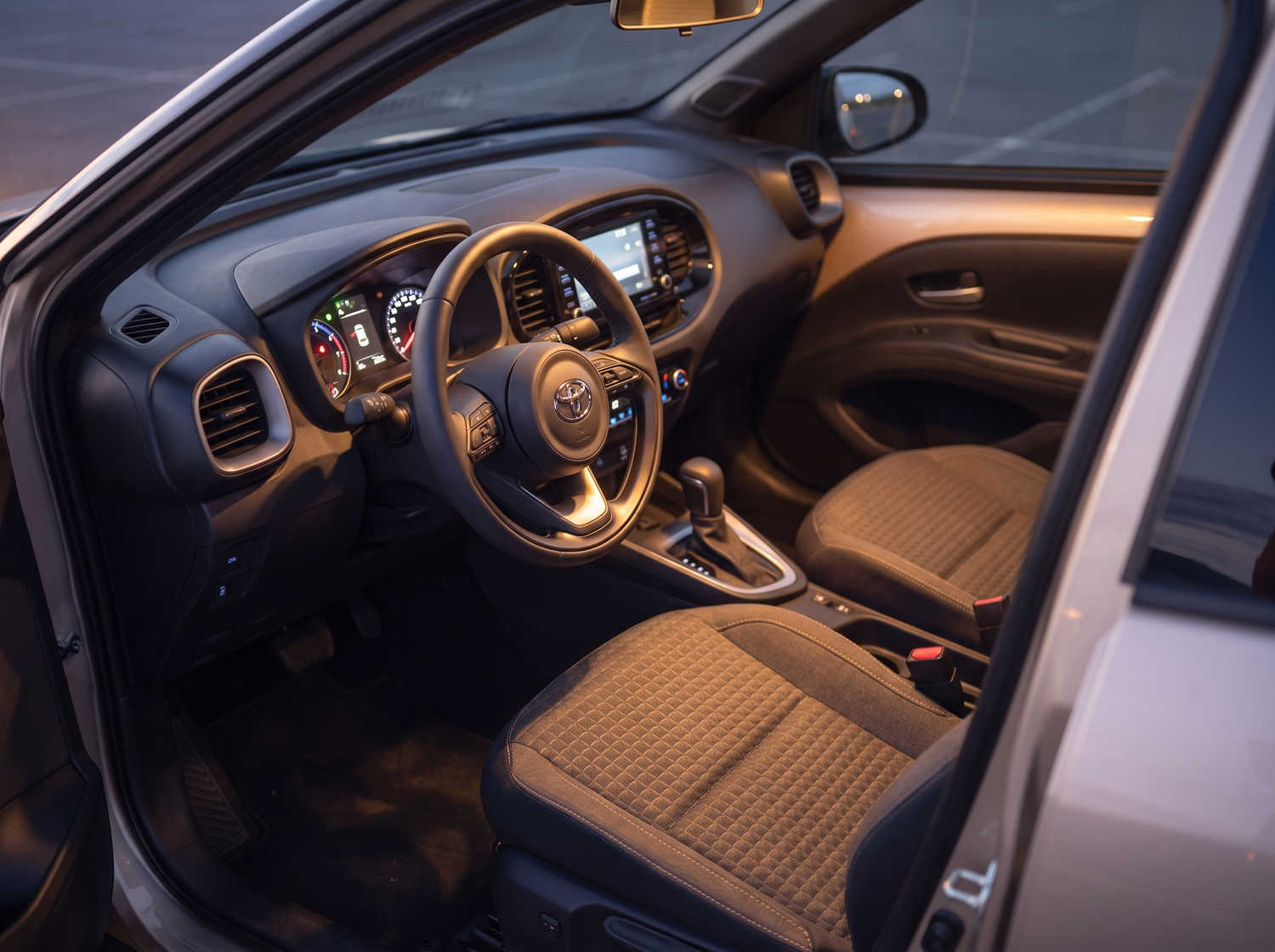 Toyota Aygo naranja vibrante con transmisión automática, ideal para 4 pasajeros, compacto y eficiente para recorrer ciudades islandesas.
