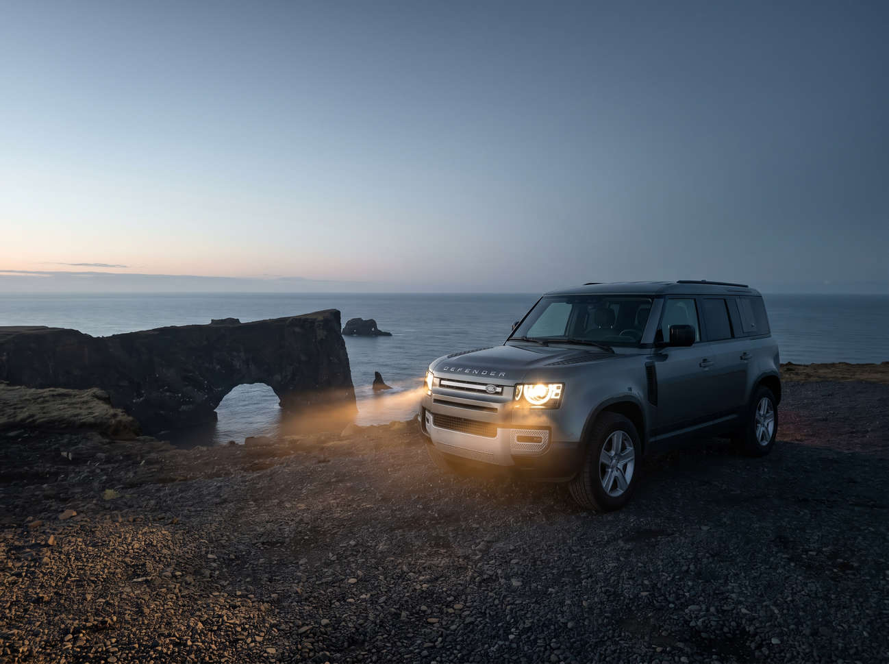 Land Rover Defender gris, SUV 4x4 de lujo con GPS, asientos calefactables, cargador USB y cámara de reversa para viajar por los terrenos más exigentes de Islandia.