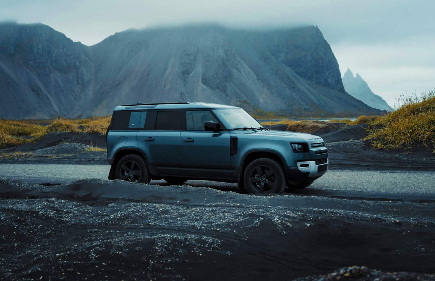 Land Rover Defender gris, SUV 4x4 de lujo con GPS, asientos calefactables, cargador USB y cámara de reversa para viajar por los terrenos más exigentes de Islandia.