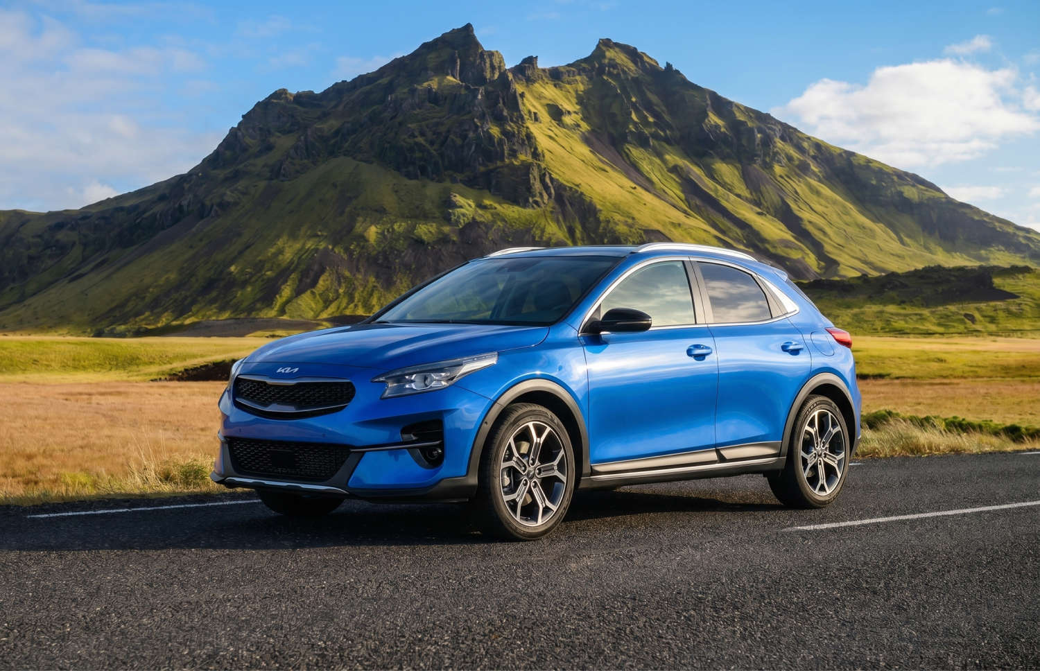Kia XCeed crossover amarillo brillante con transmisión automática, GPS, cámara de reversa y asientos calefactables; capacidad para 5 personas y 2 maletas, ideal para viajar por Islandia.