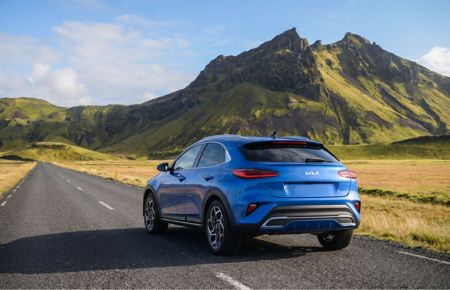 Kia XCeed crossover amarillo brillante con transmisión automática, GPS, cámara de reversa y asientos calefactables; capacidad para 5 personas y 2 maletas, ideal para viajar por Islandia.