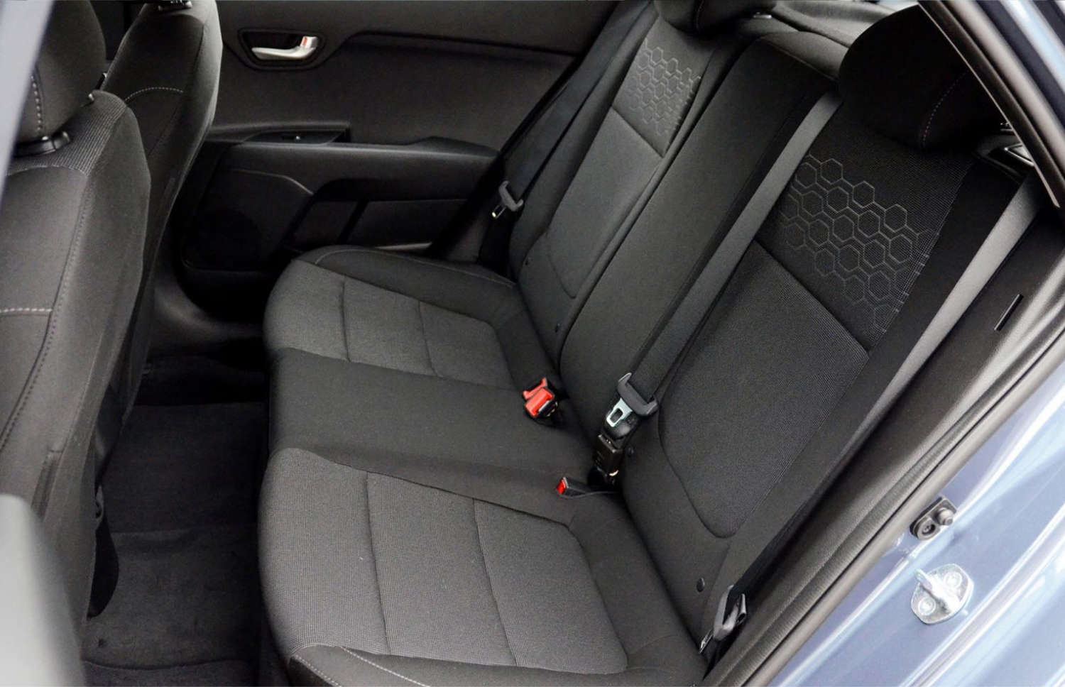 Kia Rio azul con transmisión manual, GPS, cámara de reversa y espacio para 5 pasajeros y 2 maletas, ideal para viajes por carretera en Islandia.