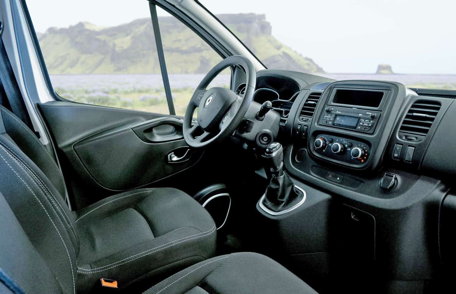 Renault Trafic roja de 9 plazas con transmisión manual, asientos calefactables, Bluetooth y cargador USB; ideal para viajes en grupo por Islandia.