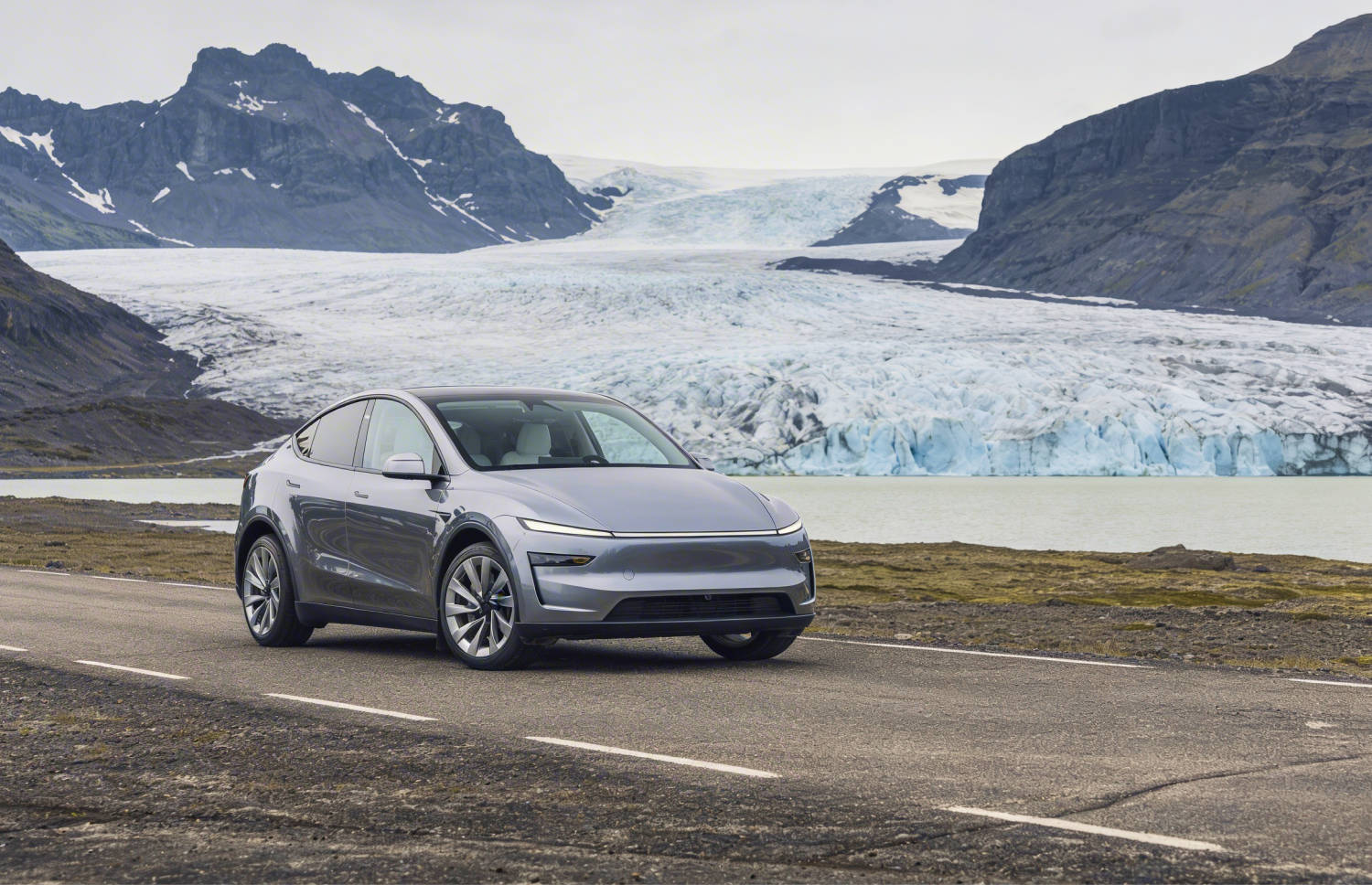 Tesla Model Y azul, SUV eléctrico con transmisión automática, GPS, cámara de reversa, asientos calefactables y espacio para 5 pasajeros y 2 maletas en Islandia.