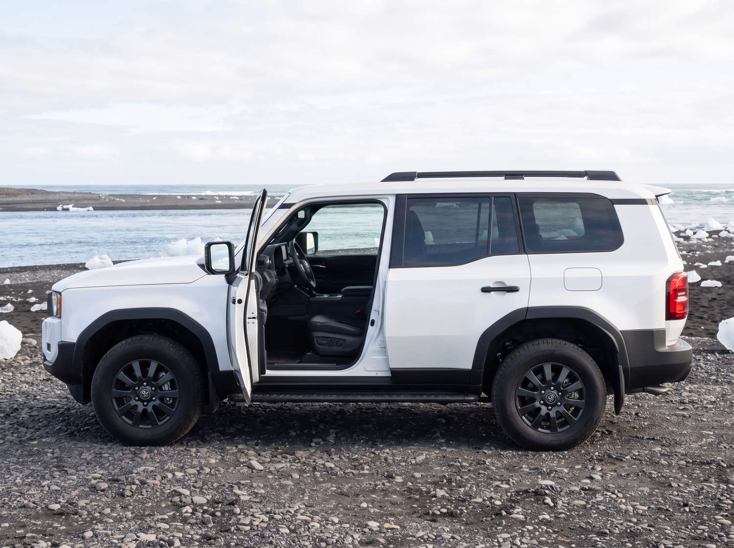 Toyota Land Cruiser 250 blanco, SUV 4x4 con transmisión automática, 7 plazas, cargador USB, Bluetooth y asientos calefactables; perfecto para aventuras off-road en Islandia.