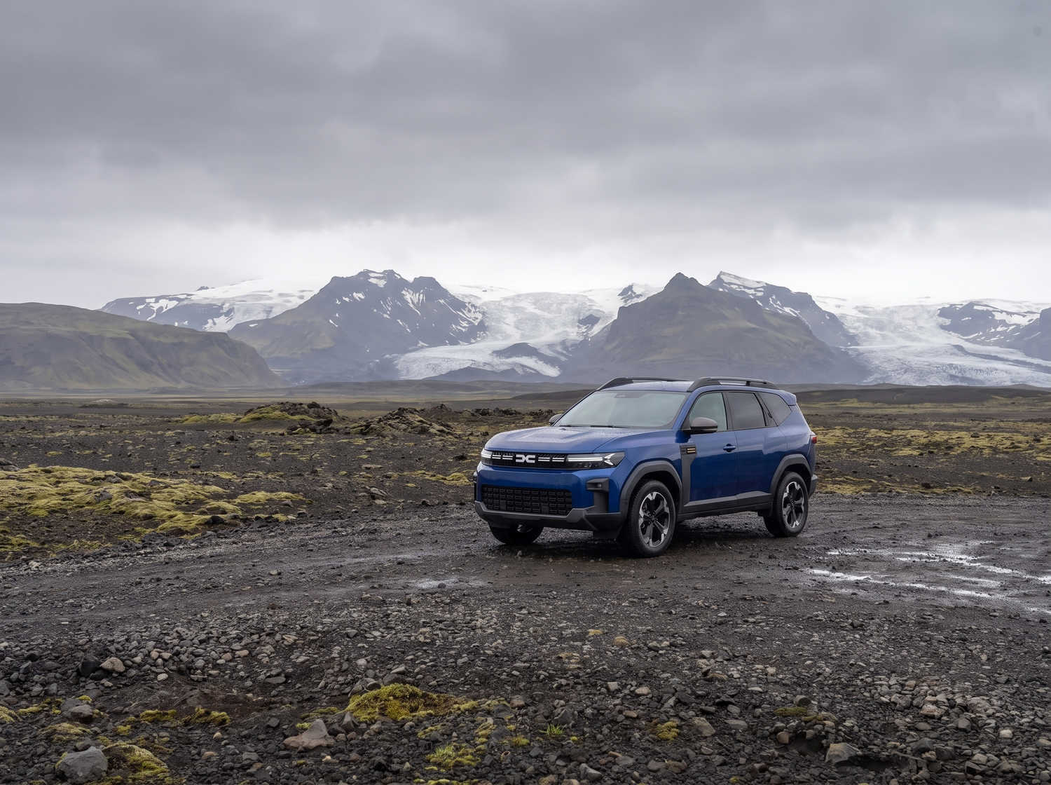 Dacia Bigster azul con transmisión manual y tracción en las cuatro ruedas, capacidad para 5 personas y 4 maletas, diseñado para las carreteras difíciles de Islandia con total comodidad.