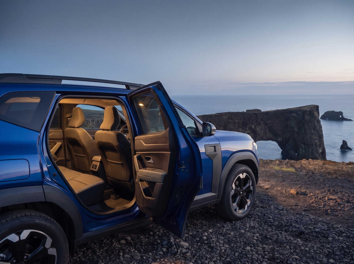 Dacia Bigster azul con transmisión manual y tracción en las cuatro ruedas, capacidad para 5 personas y 4 maletas, diseñado para las carreteras difíciles de Islandia con total comodidad.