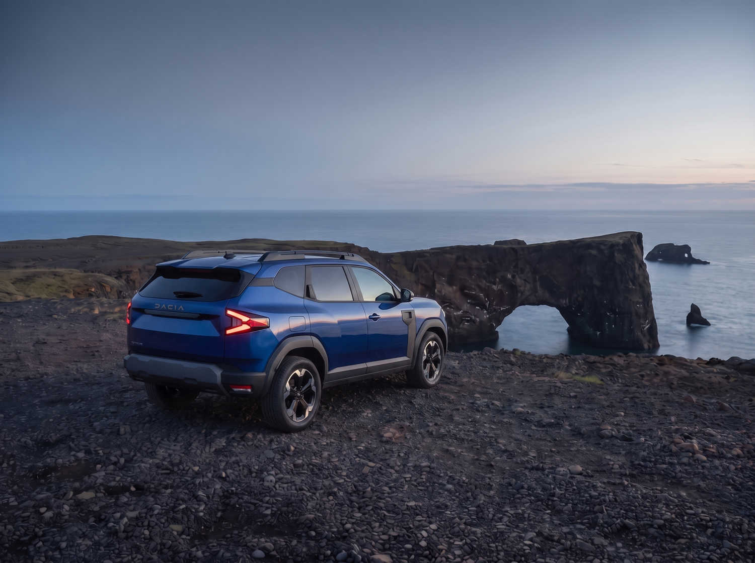 Dacia Bigster azul con transmisión manual y tracción en las cuatro ruedas, capacidad para 5 personas y 4 maletas, diseñado para las carreteras difíciles de Islandia con total comodidad.