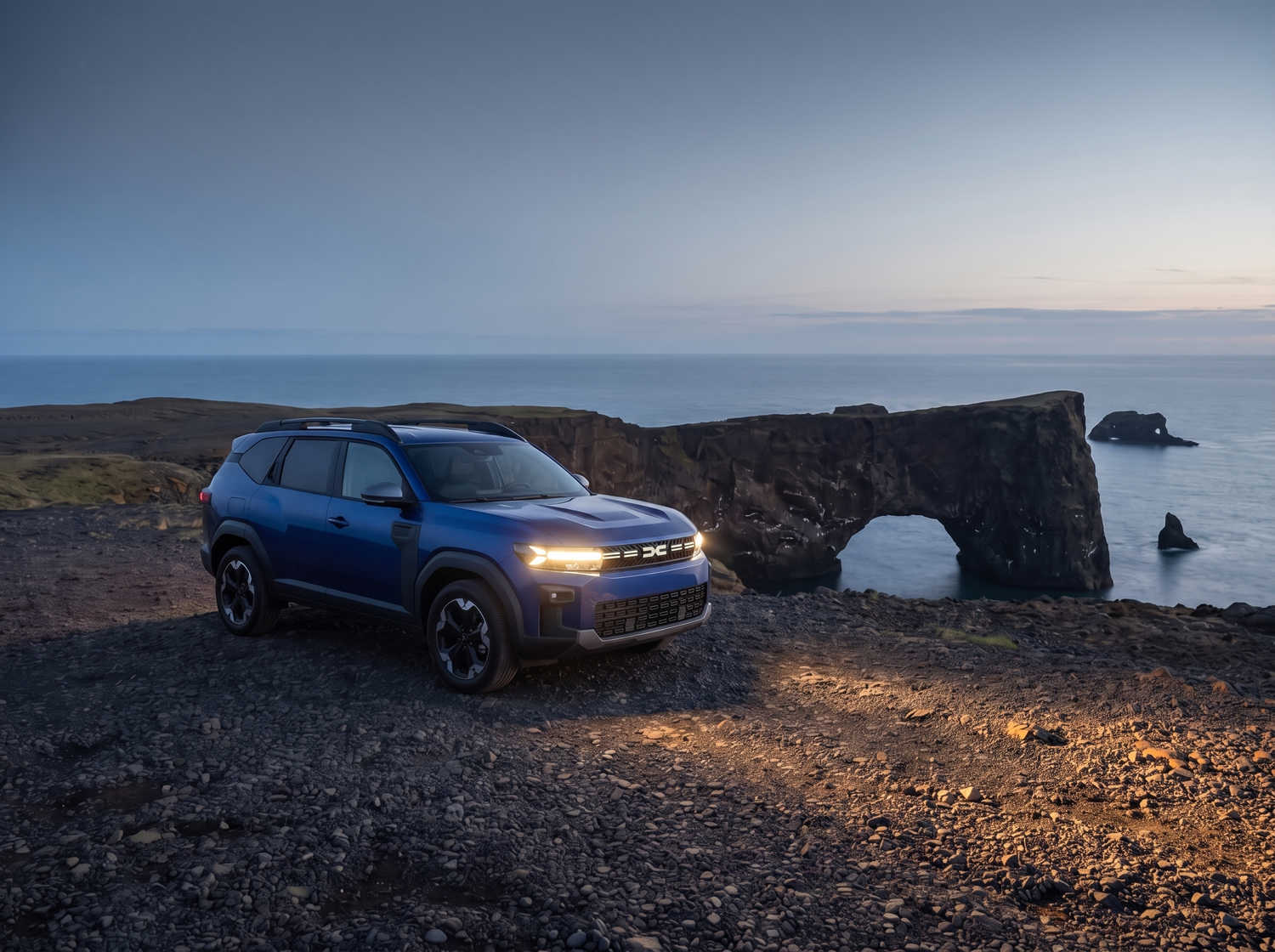Dacia Bigster azul con transmisión manual y tracción en las cuatro ruedas, capacidad para 5 personas y 4 maletas, diseñado para las carreteras difíciles de Islandia con total comodidad.