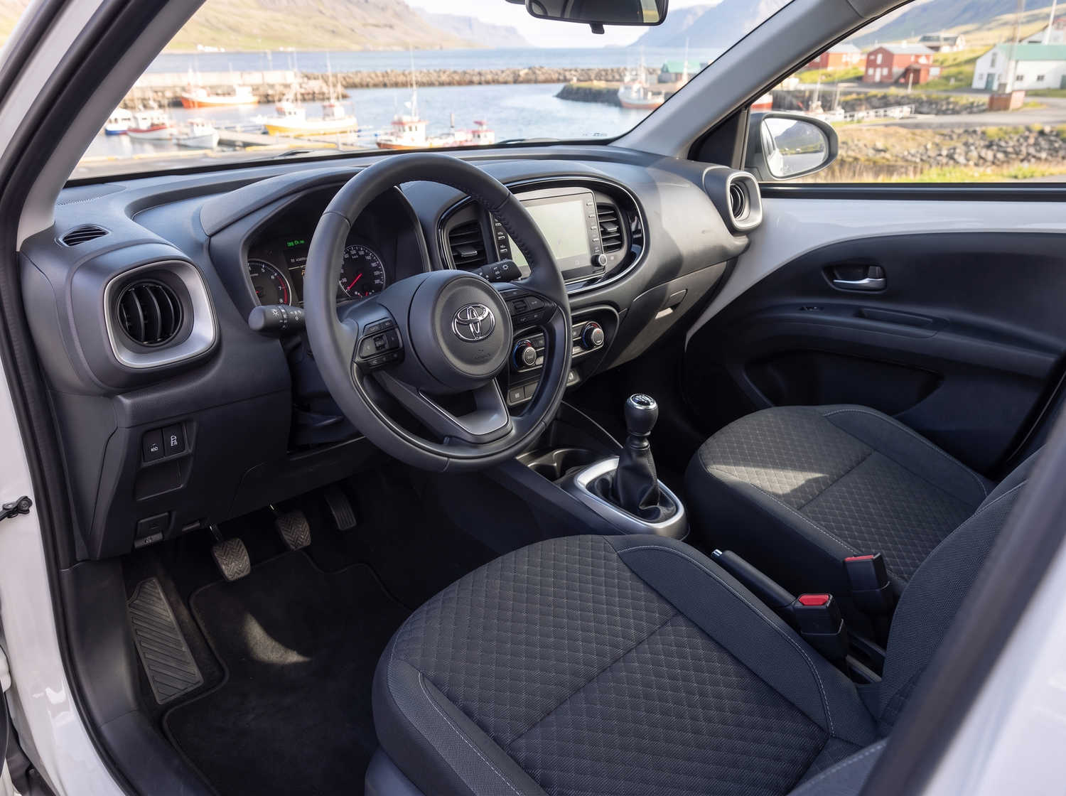 Toyota Aygo compacto en gris metálico con transmisión manual, perfecto para 4 pasajeros, ideal para conducir en ciudad en Islandia.